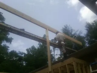 Carpenter setting a ridge beam over a new addition frame — Ice Dam Removal by Roofing Brothers in Island Lake