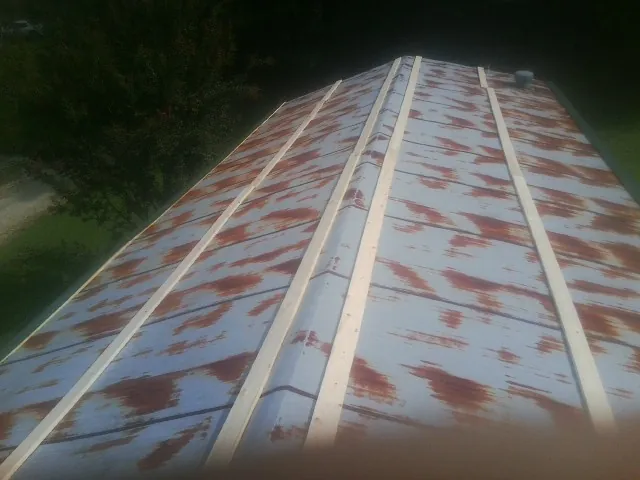 Rusted metal roof panels with new wood purlins before replacement — Storm Damage Roof Repair in Island Lake by Roofing Brothers