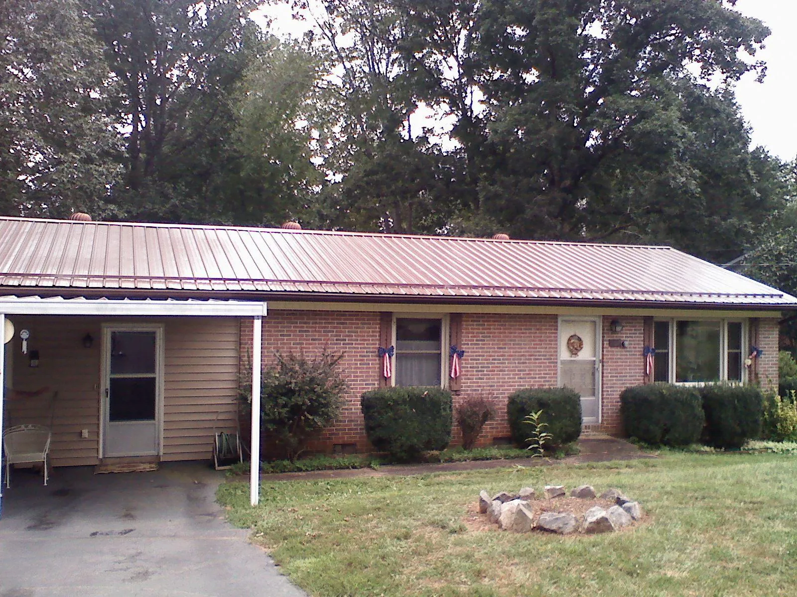 Bronze metal roof and carport on a brick ranch home — Roof Repair work by our crew in Island Lake