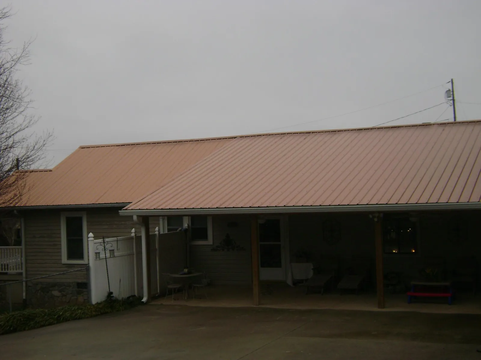 Copper toned metal roof over a wide covered patio in Island Lake